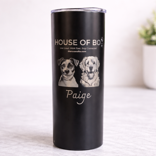 Black tumbler with dog illustrations and text on a white surface